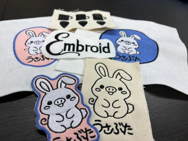 Usabuta patches and the Embroid logo stitched on felt